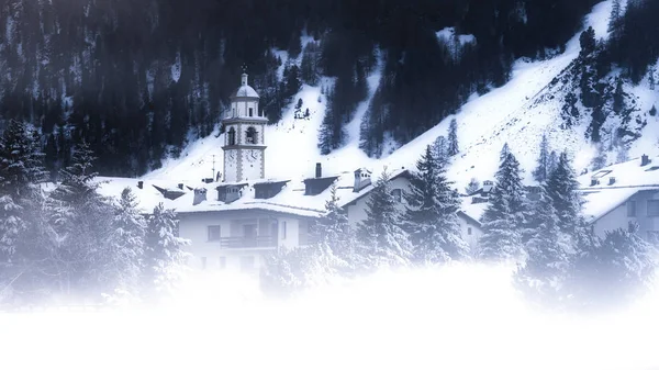 Pueblo en los Alpes suizos con niebla y nieve — Foto de Stock
