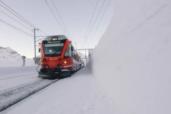 Červený vlak Grisons uprostřed spousty sněhu — Stock fotografie