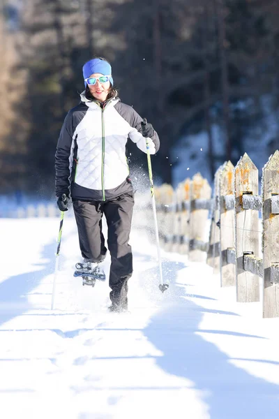 Ένα κορίτσι σε μια βόλτα με χιονοπέδιλα και κοντάρια. — Φωτογραφία Αρχείου