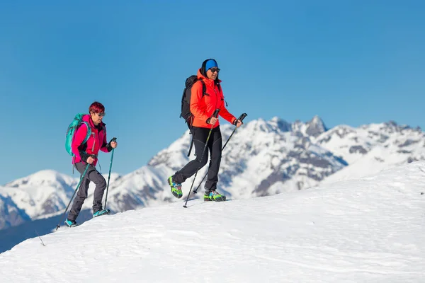 Dos amigas montañeras escalando una montaña en invierno — Foto de Stock