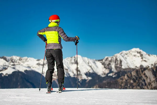 På skidbackarna i ett skidområde tittar en skidåkare på fjällen — Stockfoto