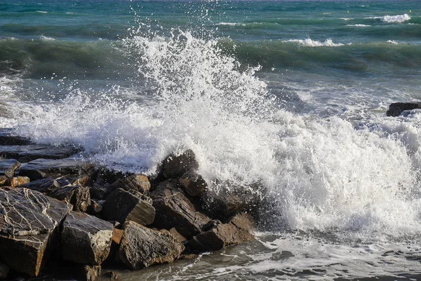Un onda che si infrange sugli scogli