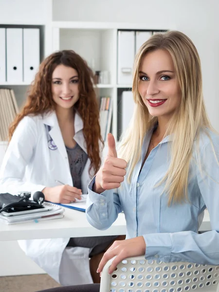 Usmívající se žena pacient ukazuje palec — Stock fotografie