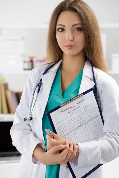 Portrait of female doctor holding patient registration form — Stock Photo, Image