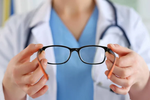 Mãos de médico oculista feminino dando par de óculos. Boa visão — Fotografia de Stock