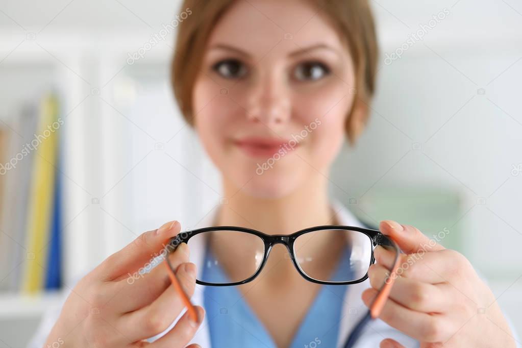 Female oculist doctor hands giving pair of glasses. Good vision 