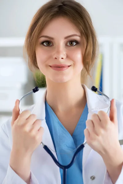 女性医学医生戴上听诊器 免版税图库照片
