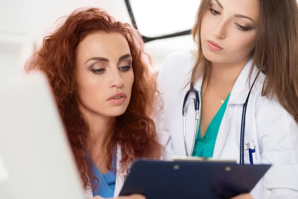 İki kadın doktorlar hasta bilgi formu at arıyorsunuz — Stok fotoğraf