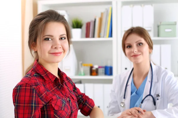 Sorridente paziente femminile seduto presso lo studio medico medicina — Foto Stock