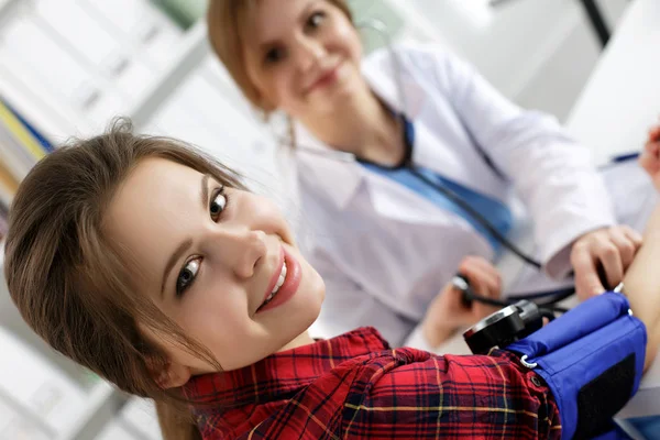 Mujer sonriente sentada en el consultorio del médico de medicina — Foto de Stock