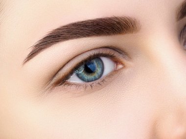 Güzel mavi kadın göz görünümünü kapatın. Mükemmel modaya uygun kaş. İyi görme, kontakt lensler, kaş çubuğu veya moda kaş makyaj kavramı