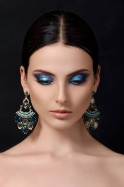 Mavi küpe ile güzel brunet kadın portresi