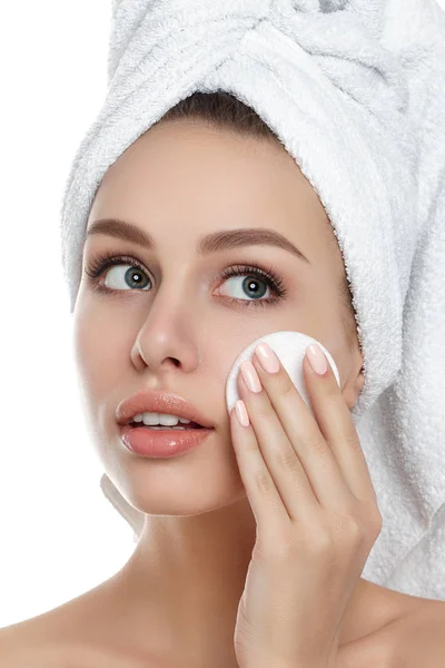 Mladá žena s ručníkem na vlasy čištění make-up — Stock fotografie
