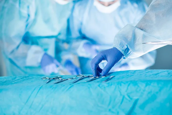 Medical team performing operation. Close up of scrub nurse takin — Stock Photo, Image