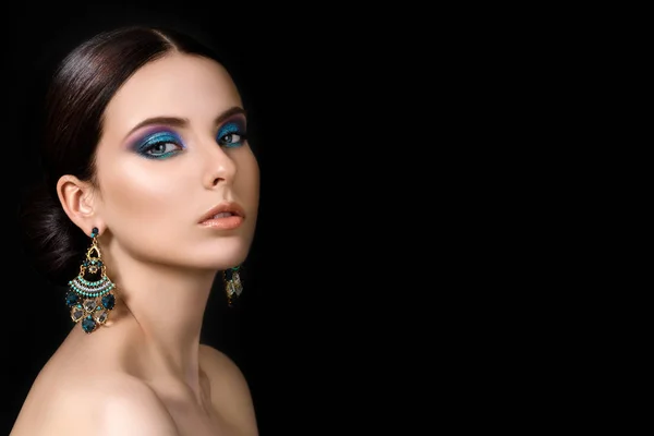Portret van mooie brunet vrouw met blauwe oorbellen — Stockfoto