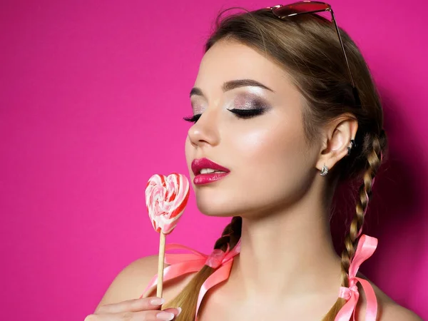 Jonge mooie vrouw houdt hartvormige lollipop — Stockfoto