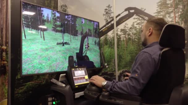 Vologda. Rusko-prosinec 2019: Muž na simulátoru těžebního stroje. Školení na počítačovém simulátoru lesního inženýrství. — Stock video