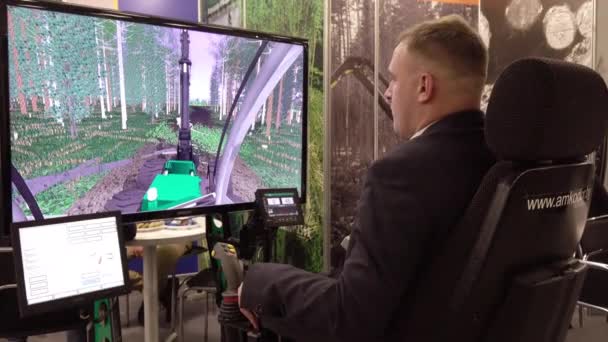 Vologda 。 俄罗斯- 2019年12月：一个在伐木机模拟器上的人。 关于森林工程计算机模拟器的培训. — 图库视频影像