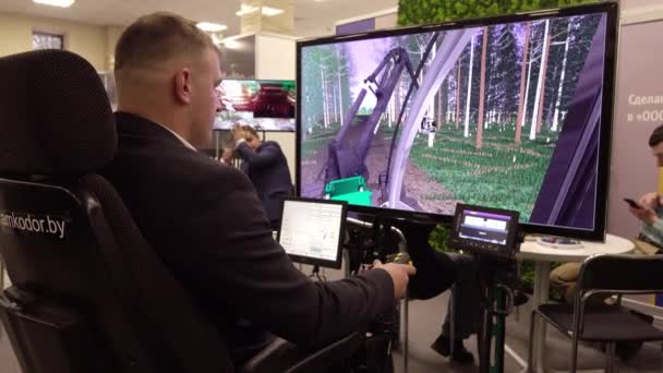 Vologda. Rusland-december 2019: een Man op een houtkapmachine simulator. Training op een computersimulator voor bosbouw. — Stockvideo