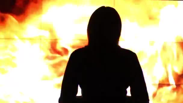 Silhouette of a woman against a virtual fire . — Stock Video