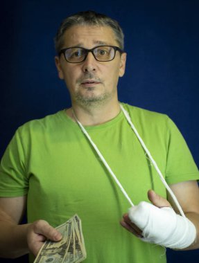 Kolu alçıda olan bir adam hastanedeki acil tıbbi bakım masraflarından ve masraflarından para saydı. .