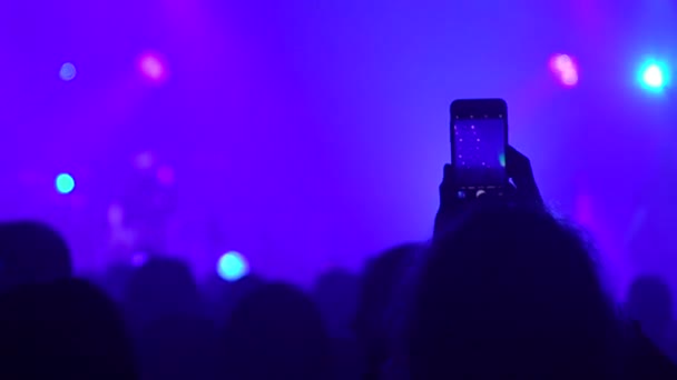 People at the concert shoot videos on their mobile phones. — Stockvideo