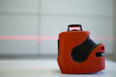 Laser level, used in apartment renovation. Optical instrument for accurate horizon level.