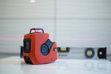 Laser level, used in apartment renovation. Optical instrument for accurate horizon level.