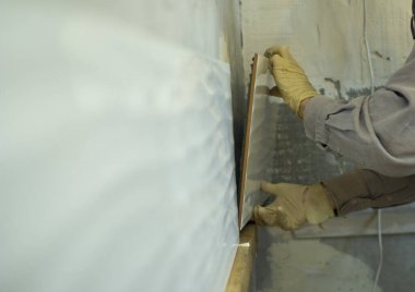 Duvardaki gri çimentodaki seramik fayansların yerleşimi. Fayansların uygulanma süreci .