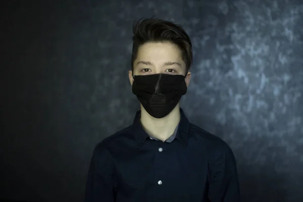 Porträt eines braunäugigen Teenagers mit schwarzer medizinischer Maske. Antivirenschutz. — Stockfoto