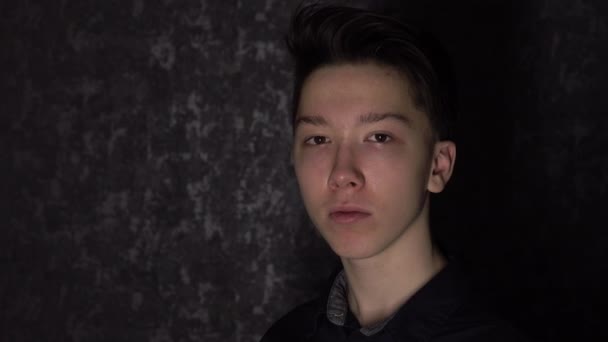 Retrato de um adolescente de olhos castanhos com uma máscara médica preta. Proteção antivírus . — Vídeo de Stock
