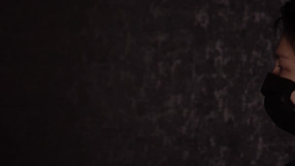 Porträtt av en brunögd tonåring i svart medicinsk mask. Antivirusskydd. — Stockvideo