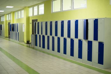 Okul koridorunda öğrenci eşyaları için çekmeceler var..