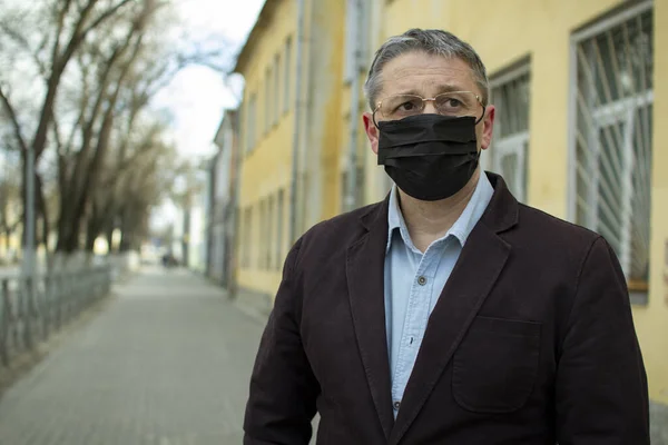 Şehirdeki tek kullanımlık siyah maskeli orta yaşlı bir Avrupalı.. — Stok fotoğraf