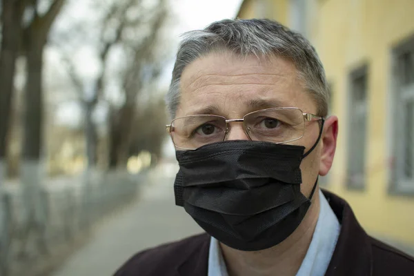 Şehirdeki tek kullanımlık siyah maskeli orta yaşlı bir Avrupalı.. — Stok fotoğraf