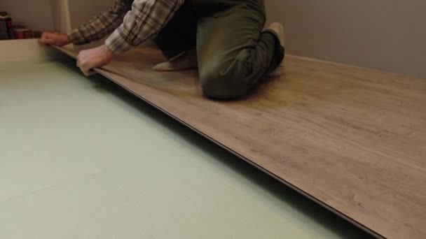 A worker puts a new laminate on the floor. Laying the floor covering. Master in the house. — Stock Video