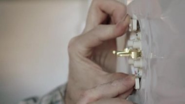 Elektrikçi prizi duvara sabitlemek için tornavida kullanır..