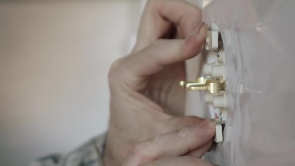 El electricista utiliza un destornillador para fijar el enchufe a la pared . — Vídeos de Stock