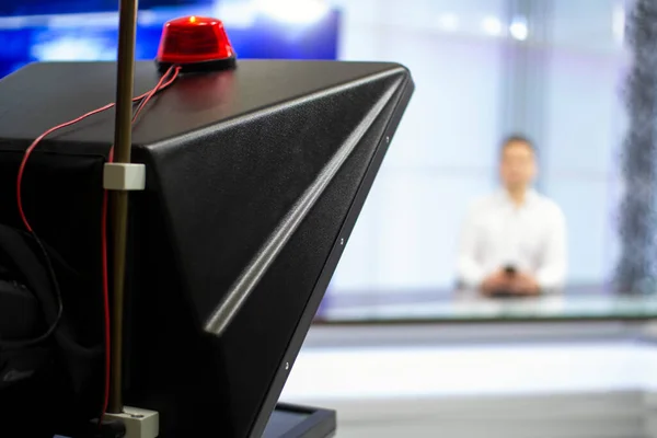 Uma âncora de notícias masculina em um estúdio de transmissão lê texto em um teleprompter. Câmera no estúdio de TV. — Fotografia de Stock