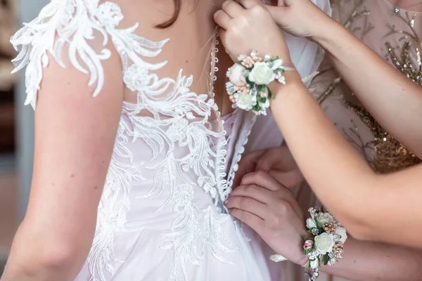 Portrait rapproché d'une demoiselle d'honneur aidant la mariée avec sa robe. jeune mariée heureuse se préparer, jeune mariée photohappy mariage se préparer, photo de mariage — Photo