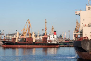 Konteynırları konteynır gemilerine, iskele vinçlerine ve yukarıdan görünen devasa gemilere yüklüyorlar. port konteyner terminali.
