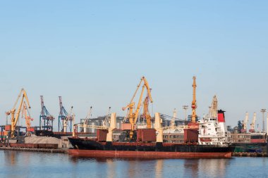 Konteynır gemisi. Lojistik İthalat İthalat Şirketi için şafakta tersanede çalışan vinç köprüsü olan sanayi konteynırı kargo gemisi..