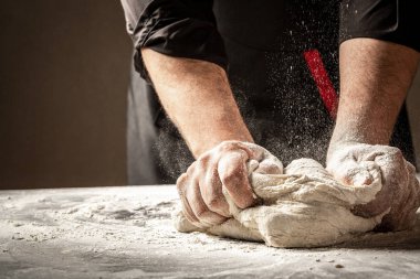 Un içinde yuvarlak ekmek pişirmek. Paskalya ekmeğinin hazırlanması. Erkek eli.