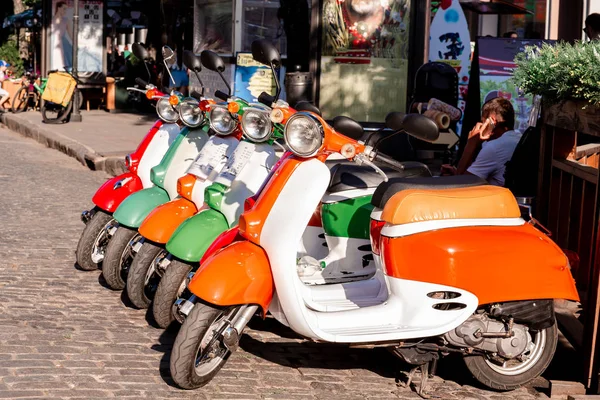 Motosiklet kiralama ve satma, scooterlar. Sokakta bir sürü scooter.