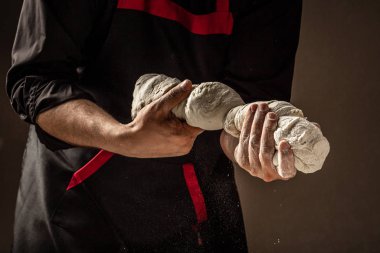 Şefin elleri ahşap arka planda hamur pişiriyor. Yemek konsepti. Erkek elleri.