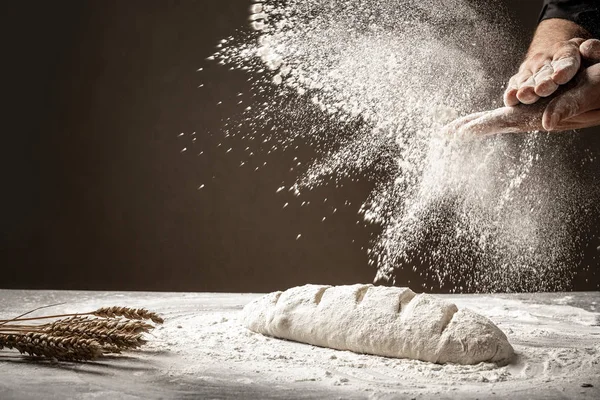 Foto de harina y manos de hombres con salpicadura de harina. Cocinar pan. Amasar la masa. Aislado sobre fondo oscuro. Espacio vacío para texto —  Fotos de Stock