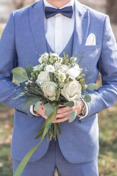 Διακόσμηση γάμου. Γαμπρός με μπουκέτο στα χέρια του. Νεαρός κομψός άντρας ντυμένος με μοντέρνα επίσημα ρούχα — Φωτογραφία Αρχείου