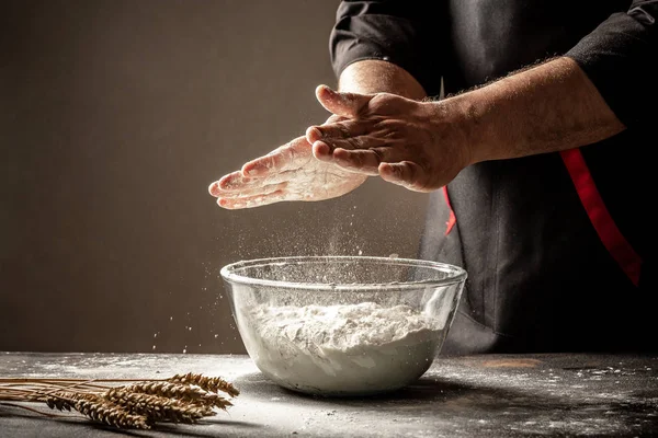 Photo of flour and men hands with flour. Cooking bread. Kneading the Dough. Isolated on dark background. Empty space for text