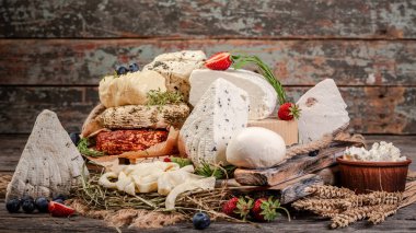 Farklı peynirler. Camembert peyniri, peynir, parmesan peyniri, mavi peynir. Arkaplan olarak kara tahta. Ücretsiz metin alanı olan bir düzen. Arkaplan resmi. Boşluğu kopyala.
