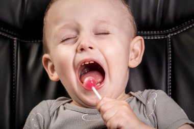 Çocuk şeker yiyor. Çocuğun dişleri fırça gibi. Diş hekimliği ve sağlık hizmetleri